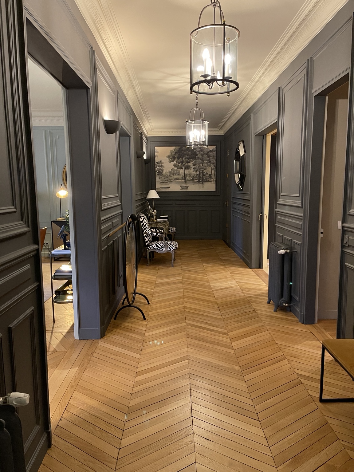 Couloir aux moulures grises et parquet en point de Hongrie