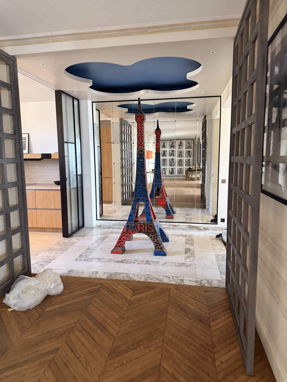 Entrée avec miroir, sculpture de la tour Eiffel et plafond décoratif bleu