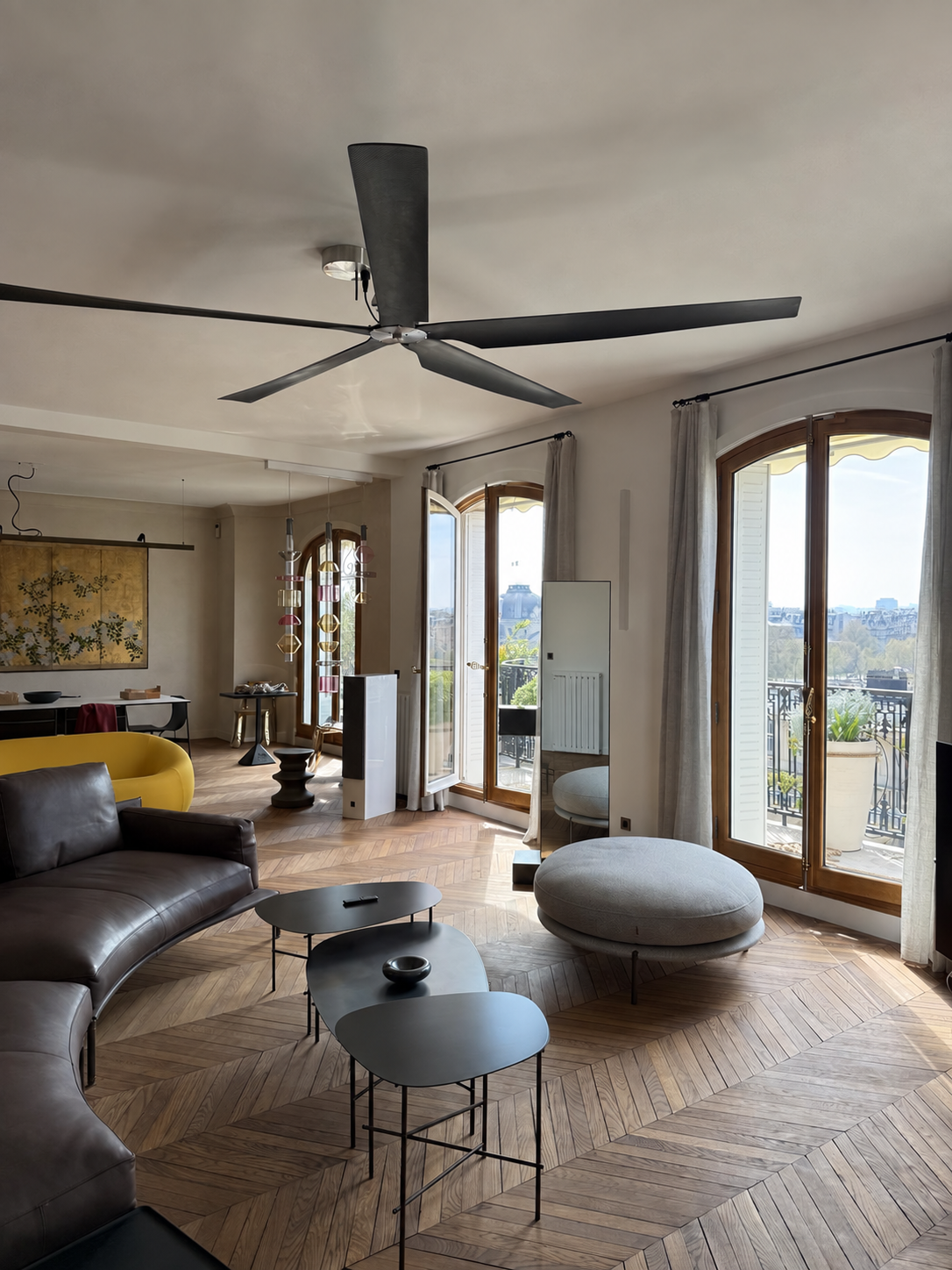 Salon lumineux avec parquet et vue parisienne